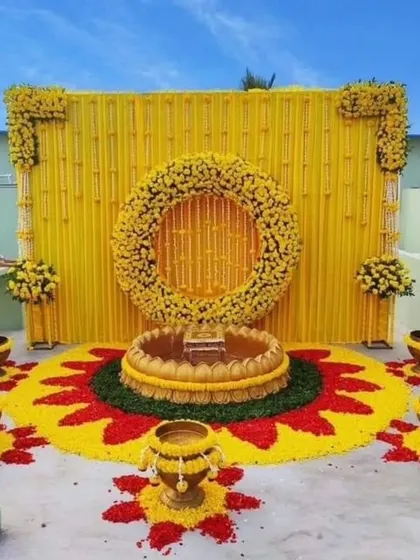 I can transform any space, even a rooftop, into a perfect venue for your Haldi. This setup includes a vibrant backdrop and a stunning floral rangoli.