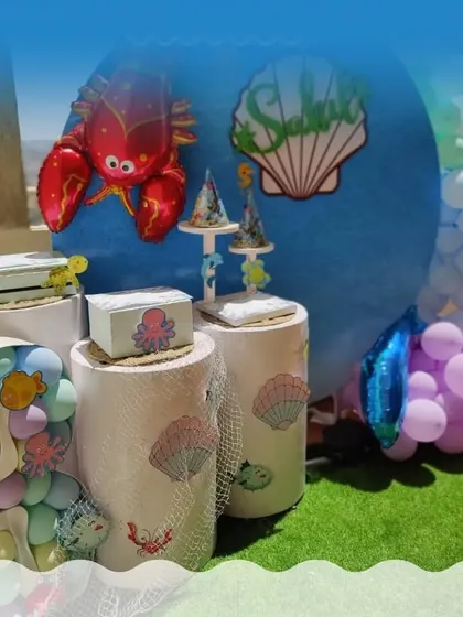 An 'Under the Sea' themed house party setup, featuring a blue backdrop, sea creature props, and balloon 'bubbles'.