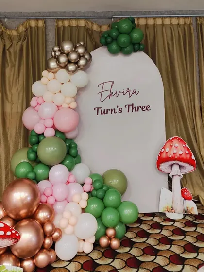 A close-up of the custom arched backdrop and balloon arrangement for Ekvira's third birthday party.