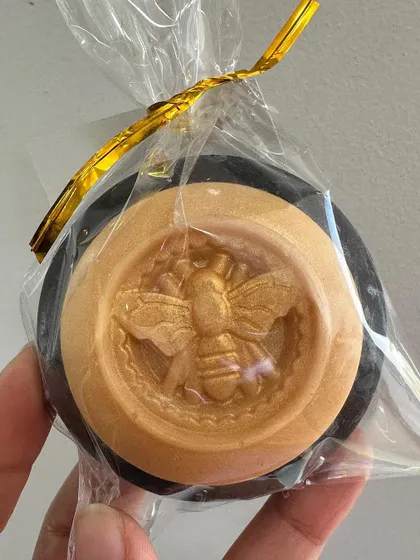 A custom-made moth gothic soap in black and gold, showing how I can match any theme for your celebration.