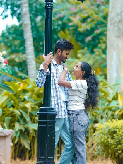 A romantic moment shared by a lamppost in a green park. This is a classic, timeless pre-wedding shot.