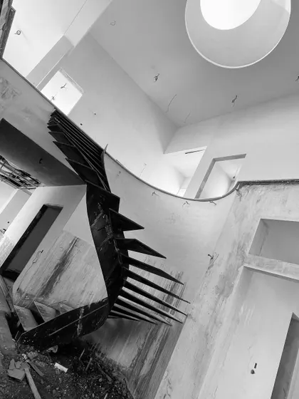 Another dramatic, angled shot of the raw steel staircase, highlighting its powerful form before the finishing materials are applied.