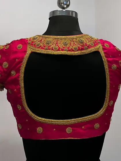 A stunning rani pink blouse with gold embroidery and a stylish square keyhole back design.