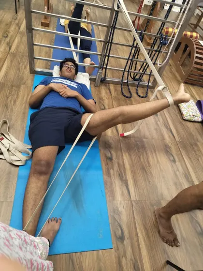 Supta Padangusthasana (Reclining Hand-to-Big-Toe Pose) with belts. The belts help to extend the leg and work on hamstring flexibility without lifting the lower back from the floor. Yoga is for everyone.