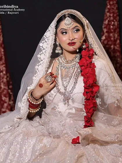A full portrait of the bride in white, where the hairstyle with the red floral braid creates a striking and memorable contrast.