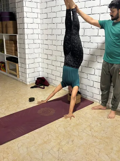 Using the wall for support is a great way to build confidence in inversions. I provide hands-on assistance to ensure proper alignment and safety in this supported headstand.