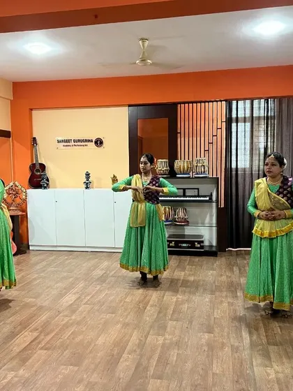 Kathak students in green anarkalis performing a synchronized piece for their examination.