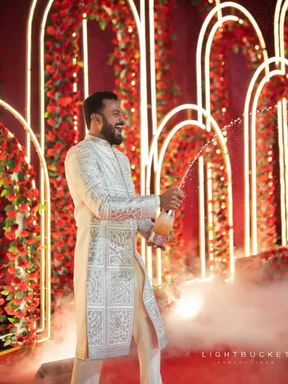 The groom pops a bottle of champagne on stage, kicking off the Sangeet party with a bang.