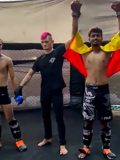 Celebrating a well-deserved win. Sriharsha's arms are raised in triumph after showcasing his skills in the cage.
