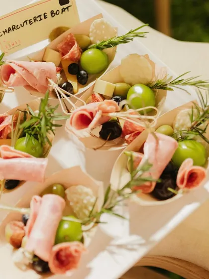 Perfect for mingling, my individual charcuterie boats are a guest favorite. Each boat is a personal treasure of cured meats, fresh grapes, olives, and cheese, garnished with rosemary. It's a sophisticated and convenient way to enjoy gourmet bites.