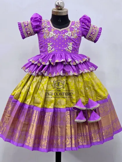 A beautiful designer lehenga in purple and lime green. The purple peplum top has two tiers of ruffles and is adorned with delicate floral maggam work.
