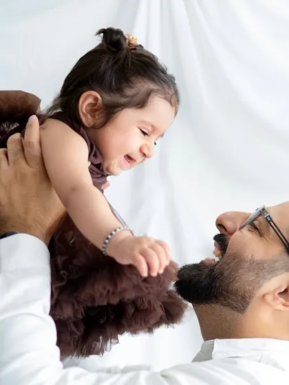 A father's joy is evident as he lifts his laughing baby girl. These close-up shots are full of emotion and make for powerful memories.