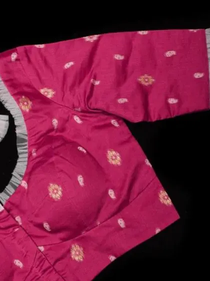 A close-up of the sleeve and neckline of our pink Jamdani cotton blouse.
