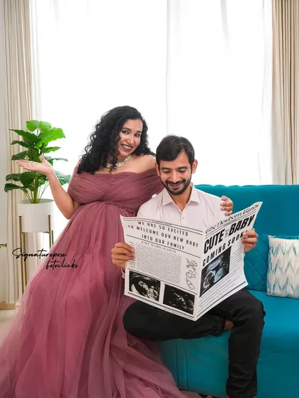 The newspaper prop adds a touch of whimsy to this happy couple's portrait in our modern studio setup.