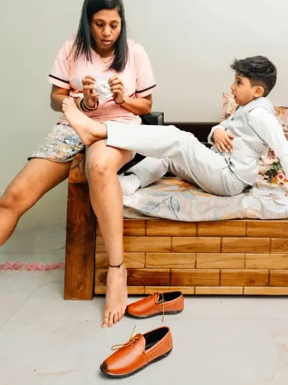 A candid moment of a sister helping her little brother with his socks. These quiet, behind-the-scenes family moments are priceless.