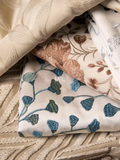 A closer look at the Bloomweave Collection, highlighting the delicate poetry of florals and foliage in shades of blue, brown, and pink on a neutral base.