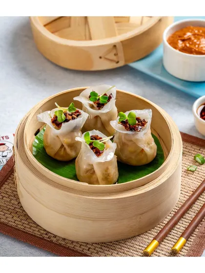 Open-faced shumai dumplings with a savory meat filling, garnished with microgreens.