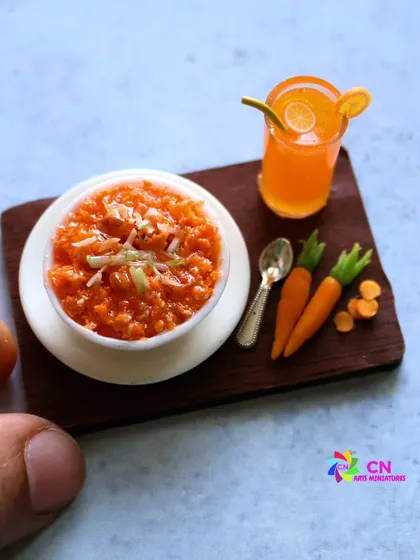 A wonderful handmade miniature of carrot halwa (gajar ka halwa) served with tiny carrots.
