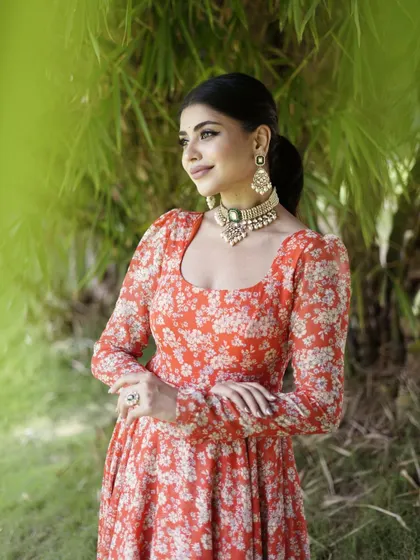A vibrant orange floral Anarkali, perfect for a summer celebration.