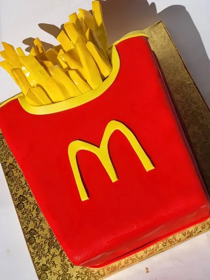 While buttercream is my go-to, sometimes fondant is necessary to achieve a specific look. This McDonald's fries cake is a great example of a fun, sculpted design.