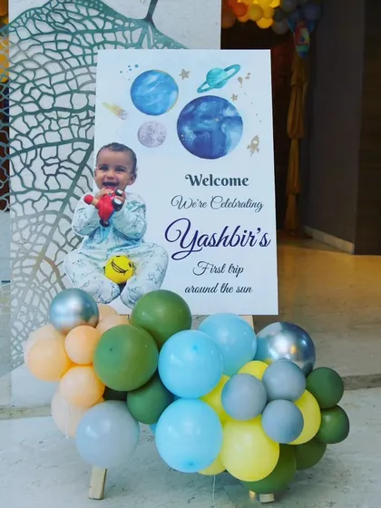 A personalized welcome board for Yashbir's space-themed party, featuring a photo of the birthday boy.