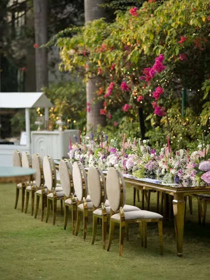 The seating arrangement for a formal corporate dinner. The combination of plush chairs, a reflective tabletop, and a dense floral centerpiece creates an atmosphere of refined elegance for guests.
