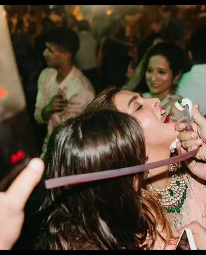 A guest enjoys a drink from our shot dispenser on the dance floor. We bring the party to you, ensuring no one misses out on the fun.