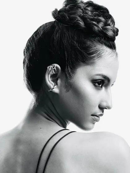 A closer view of the intricate braided bun. This black and white shot highlights the texture and skill involved in creating a sculptural and elegant hairstyle for a high-fashion look.