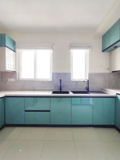 A wider view of the sink area, showcasing the expansive countertop and the sleek, glossy finish of the teal cabinets. The design is both beautiful and highly practical for daily use.
