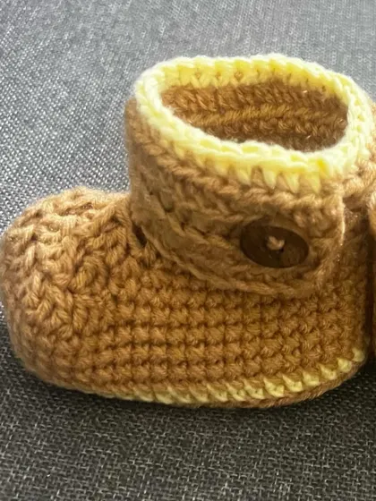 A close-up of my adjustable baby booties in a warm brown and yellow. They are soft, warm, and perfect for tiny feet.