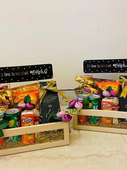 Welcome hampers for wedding guests, designed to kickstart the #DhruvGia celebrations. These wooden crates are filled with snacks, drinks, and a mini Black Label.