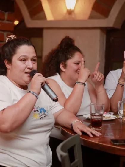 A guest confidently takes the mic from her table. You can sing from anywhere in the house.