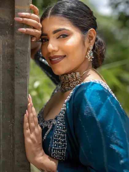 A close-up portrait. The makeup features a bold lip and defined eyes, creating a look that is both confident and beautiful.