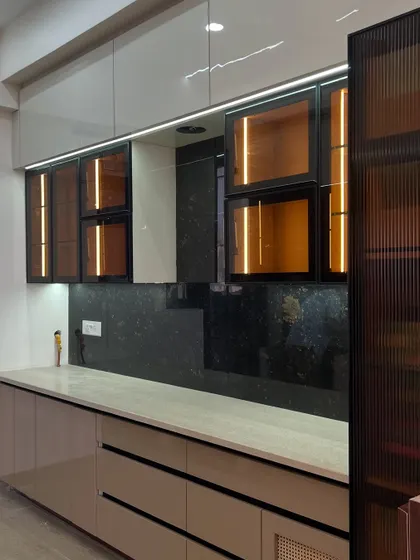 Another angle of the beige and black kitchen, showing the fluted glass pantry unit and the clean, linear design of the base cabinets. This is a great example of our custom turnkey solutions.