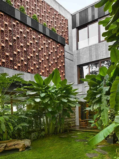 A closer look at the courtyard in Project 58, where a custom-designed terracotta screen provides privacy and filtered light, while serving as a backdrop for the dense garden.
