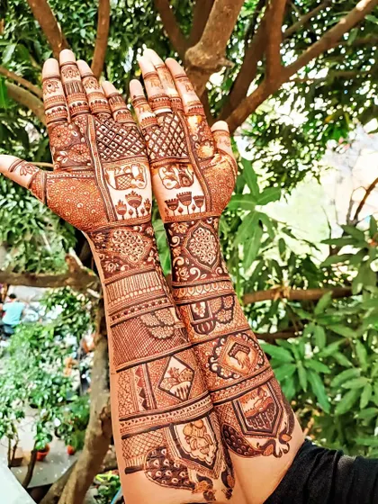 A full bridal mehendi telling a story with different elements on each arm. From peacocks and lotuses to elephants and personalized figures, this design is a true work of art.
