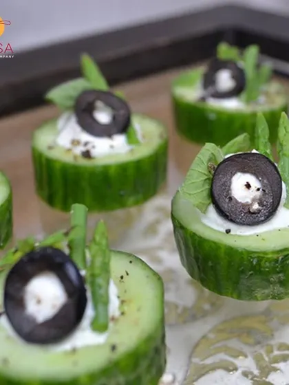 A light and healthy appetizer choice. These cucumber cups are filled with herbed cream cheese and topped with a black olive, offering a refreshing bite for any corporate wellness event or lunch.