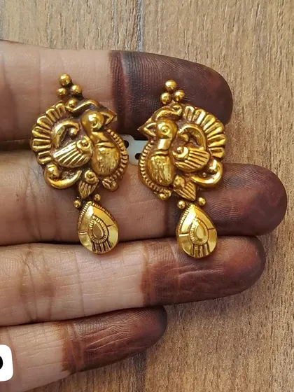 These peacock-themed earrings are crafted from 92.5 sterling silver with an antique gold plating. The teardrop-shaped drop completes the elegant design.