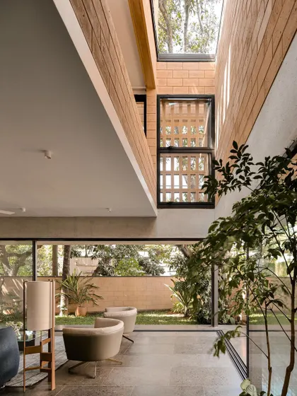 (Duplicate of 47) Light from a high skylight washes down a wall of debris blocks, highlighting the material's unique texture and bringing a sense of height and airiness to the living space.