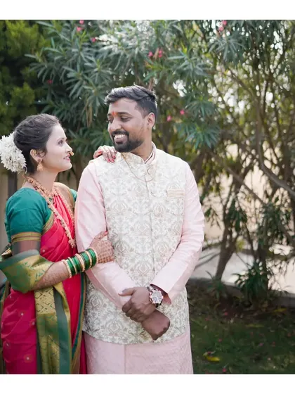 A classic couple portrait from an engagement ceremony, with the bride and groom in traditional Maharashtrian attire, sharing a happy look.