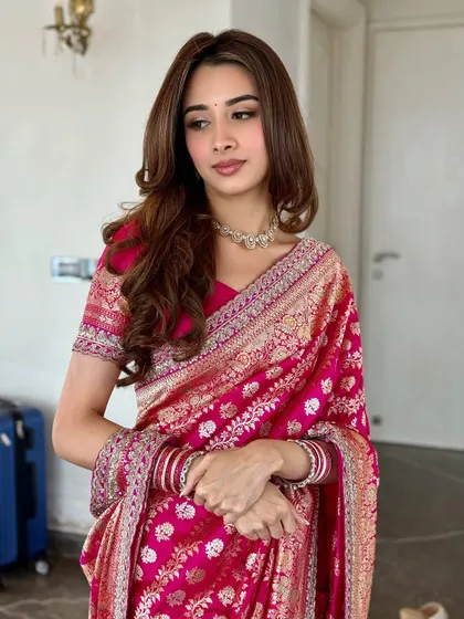 A three-quarter portrait showing the elegant drape of the saree. The soft curls and minimal makeup create a timeless look.