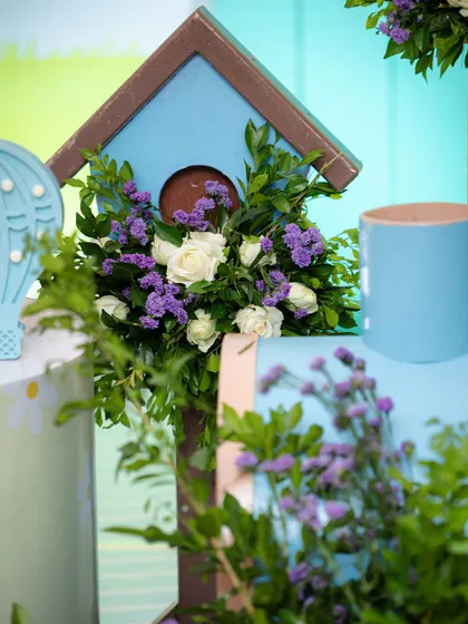 A birdhouse filled with flowers is a sweet and whimsical detail from the travel-themed party. I love incorporating natural elements into my designs.