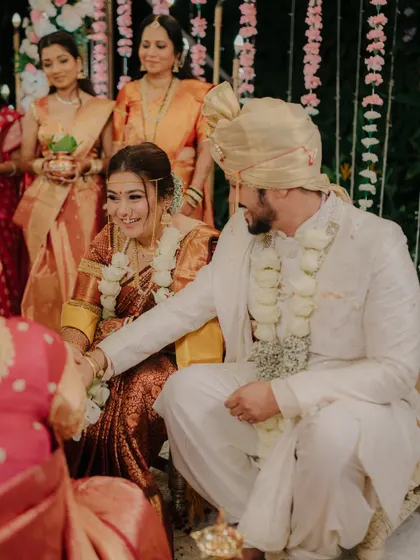 A candid moment of interaction during the wedding ceremony. The groom's gentle gesture and the bride's smile show their easy rapport.