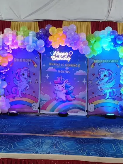 A magical unicorn-themed birthday party with multiple backdrops and cute unicorn character cutouts.