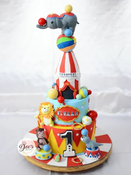 Step right up to the greatest cake on Earth. This three-tier carnival cake is a spectacle of fun, with a balancing elephant, a ringmaster lion, and a seal act, all sculpted from fondant.