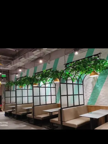 I added simple green foliage to the tops of these booth dividers in a restaurant. This small touch helps to define the seating areas and adds a bit of nature to the interior design.