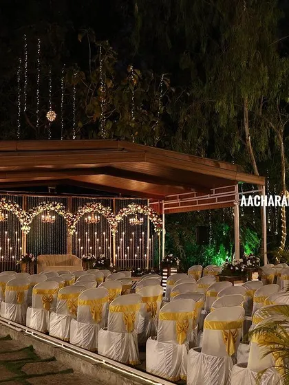 A wider perspective of the outdoor venue, showing the seating arrangement and the stage. This kind of setup is perfect for resorts or venues with beautiful natural surroundings in places like Chikmagalur or Hassan.