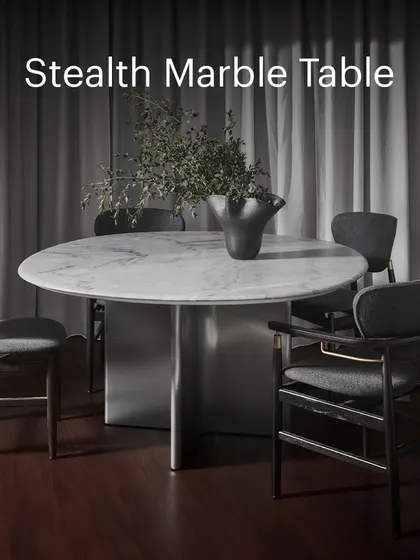 A full view of the Stealth Marble Table, surrounded by contemporary dining chairs. The cool, elegant marble and dark wood create a dramatic and luxurious dining experience.