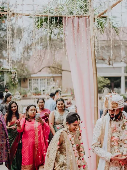 The couple's grand entrance to their garden wedding, showered with petals by their loved ones.