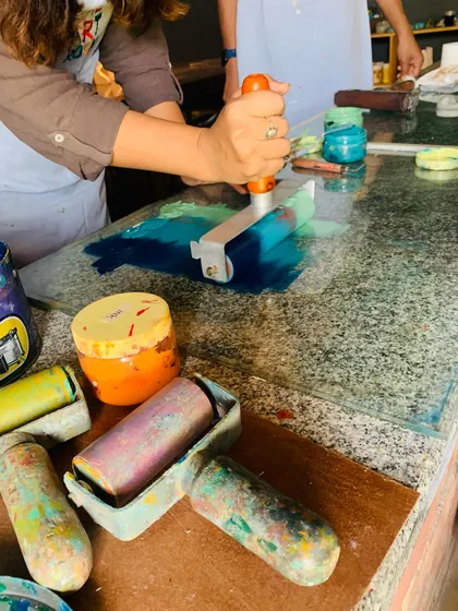 Our studio is always stocked with vibrant inks. A student learns to mix colors and load her brayer, getting ready to apply ink for a multi-color print. This is a key skill in many printmaking techniques.